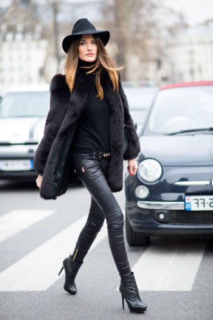 chapeau femme capeline noir une femme vetue en pantalon en cuir avec un manteau avec manteau en forrure devant une voiture
