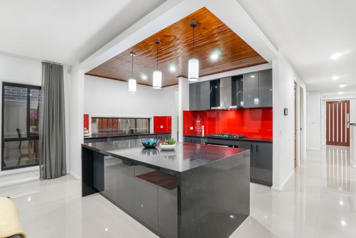 crédence cuisine en verre rouge dans une cuisine grise plafond bois et sol blanc laqué idée modele cuisine moderne