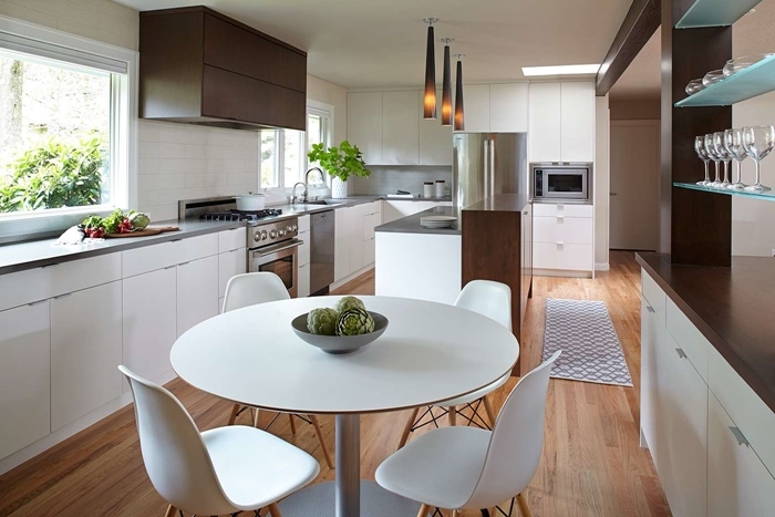 cuisine équipée moderne table à manger ronde blanche chaises plan de travail gris armoires marron