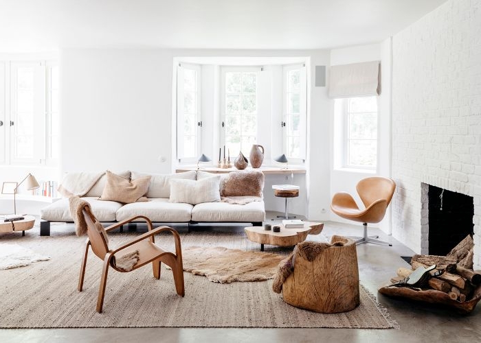 deco salon scandinave style minimaliste avec canapé bas avec coussins gris clair chauses tabouret bois cheminée blanche moderne murs blancs