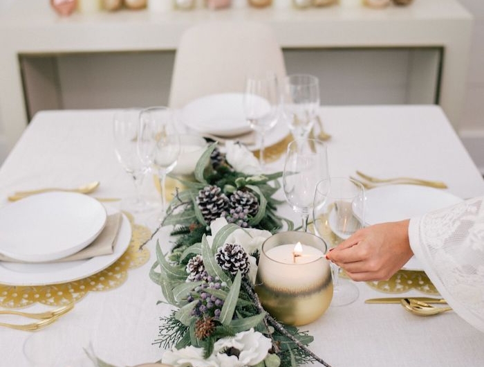 deco table de nouvel an avec des couleurs neutres et des elements metalliques et naturels des bougies sur un commode au fond de la piece