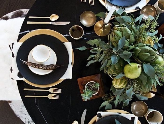 deco table nouvel an 2021 avec des couverts en or et un bouquet vert d artichaut decoration de plumes