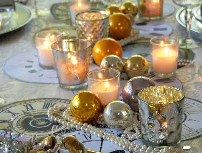decoration table reveillon saint avec des bougies et bouels de noel un bol plaine de bonbons des napperons dessines commes des horloges