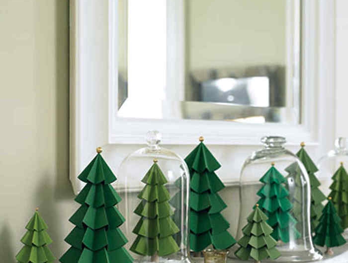 des petits sapin decoratif en papier pres d un miroir avec des couvercles en verre