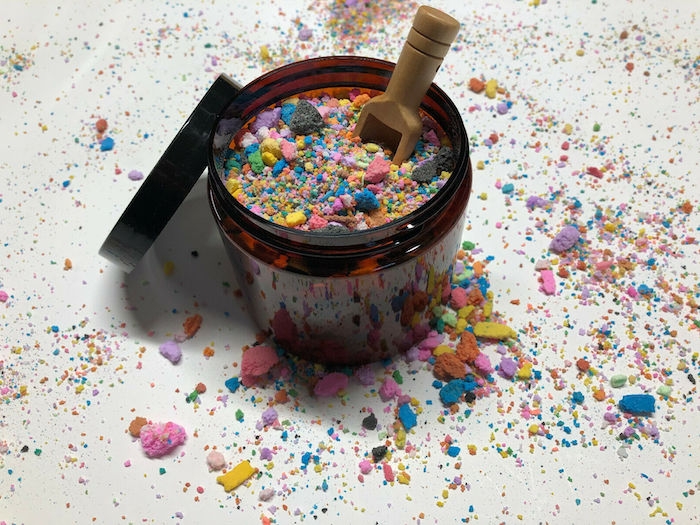fabriquer ses cosmétiques un produit de bain decore avec poudre muticolore dans un pot avec une cuillere en bois