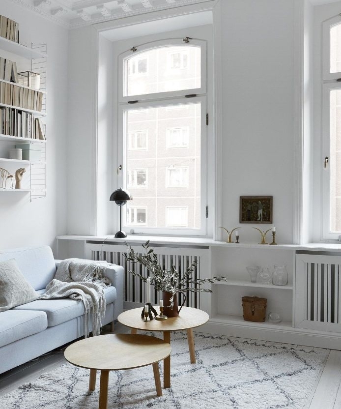 murs blancs tapis gris clair canapé blanc grandes fenetres tables gigognes ambiance cosy de salon nordique chic
