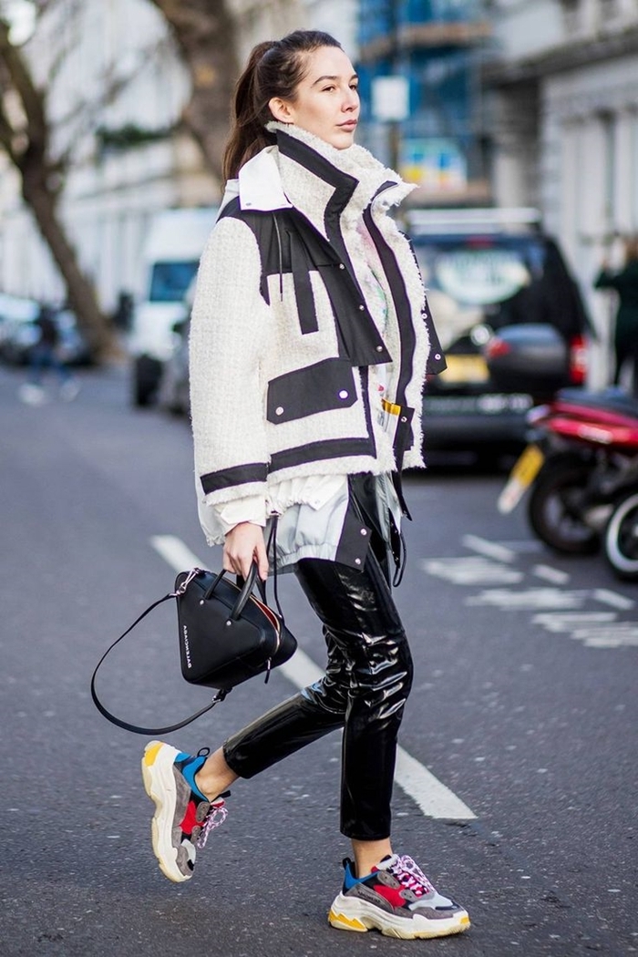 outfit streetwear femme pantalon cuir noir baskets multicolore sac à main noir veste blanc et noir