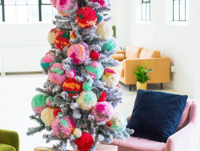 pompons colorés géants pour décorer un sapin de noel artificiel aux branches à effet enneigé dans salon moderne
