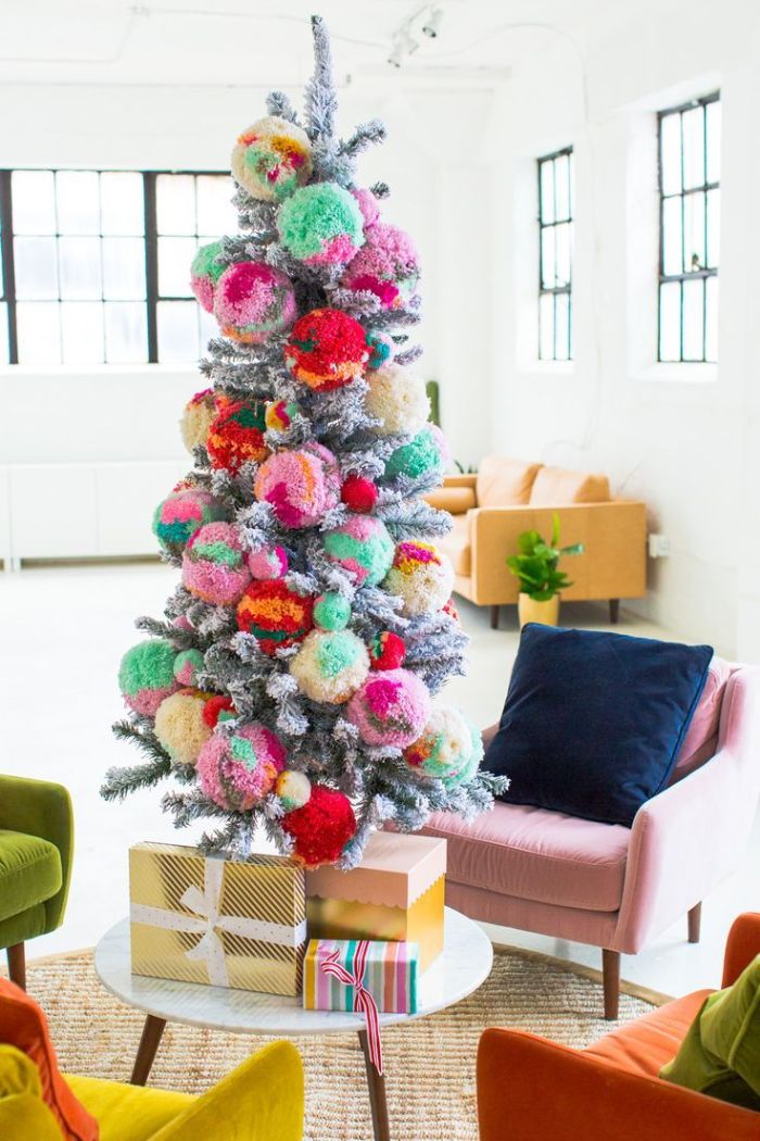 pompons colorés géants pour décorer un sapin de noel artificiel aux branches à effet enneigé dans salon moderne