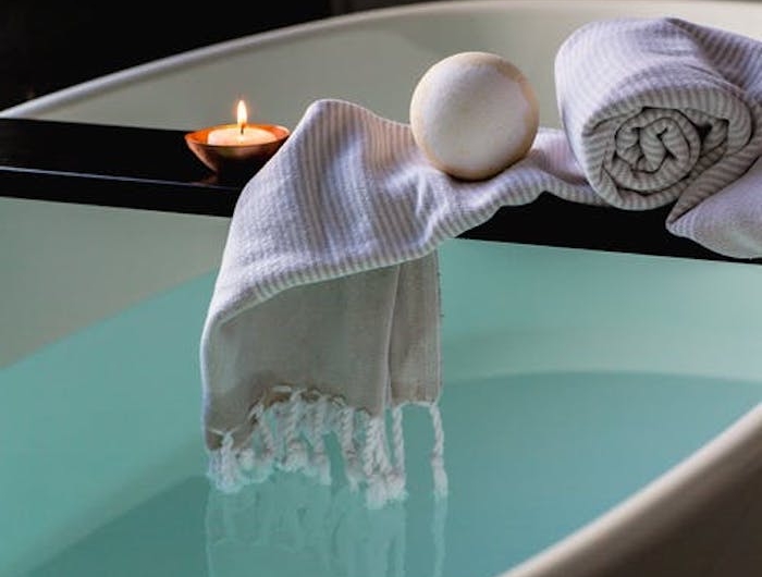 produit fait maison une boule de bain sur une paille au dessus du bain avec une serviette a rouleau