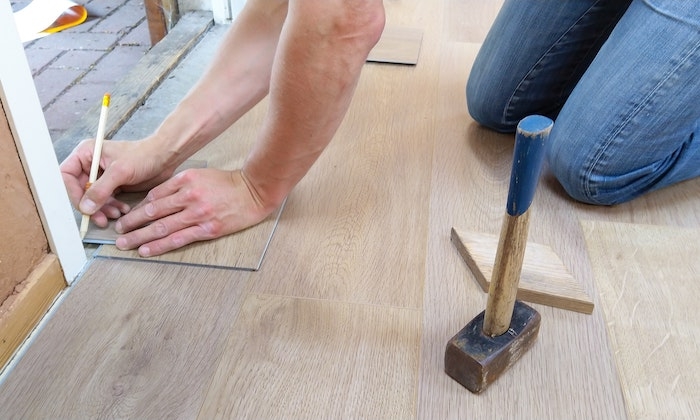 renovation du domicile deux mains qui tiennet un crayon avec un marteau pose au sol