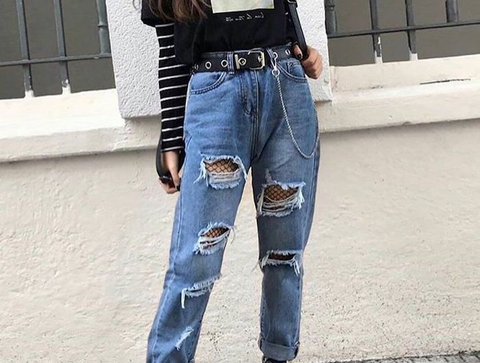 style grunge femme avec un jean dechire et des bas résillés combines avec une blouse a rayures et un t shirt dessiné