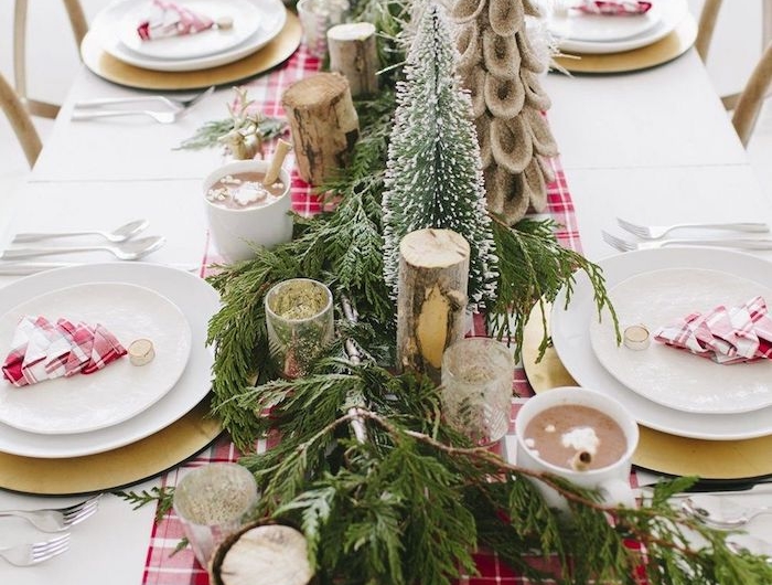table de noel rouge et blanc avec des branches de sapin et des bougies decoration cosy et rustique