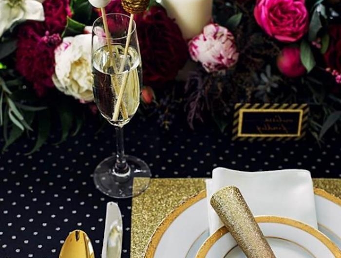 table de nouvel an avec des decoration de fleurs et une thematique en noir et or
