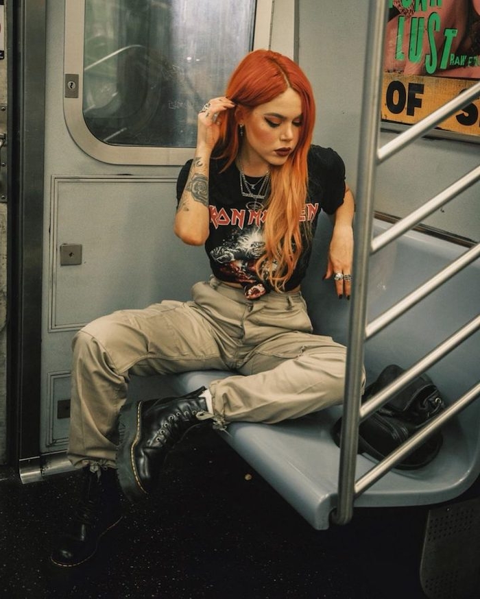 tenue aesthetic années 90s avec des bottes en cuir et t shirt iron maiden avec des cheveux tintes en rouge
