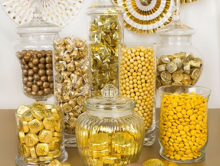 un buffet candy dans des couleurs jaunes dorees avec des bonbonnieres en verre et decorations
