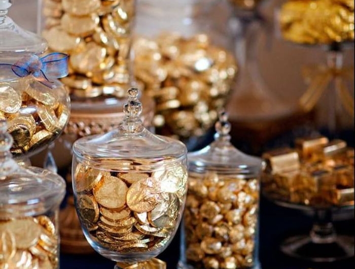 un buffet de bonbons en chocolat enveloppes en papier dore ranges sur une nappe bleue