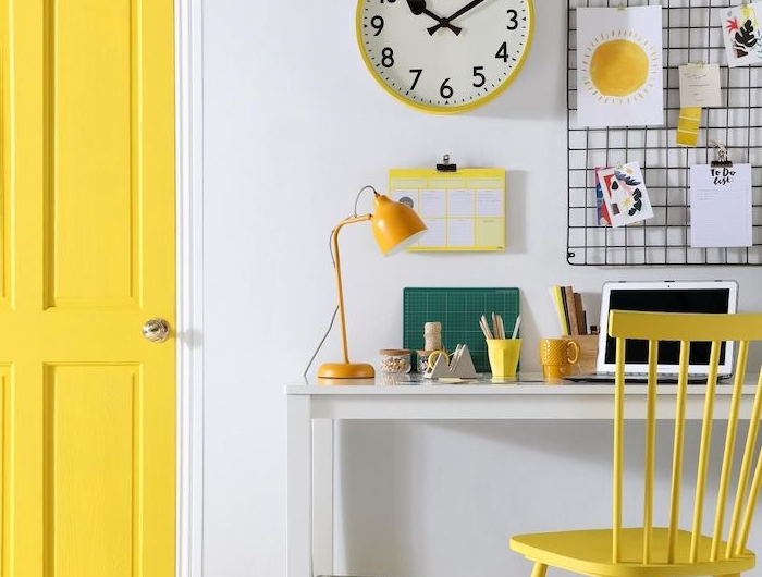 un bureau avec des elements en jaun un horloge au mur et valise au sol couleur tendance 2021