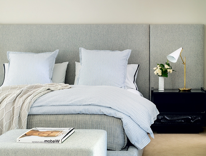 un lit avec une table en tissu gris et un chevet noir des couettes en carreaux couleur tendance deco 2021
