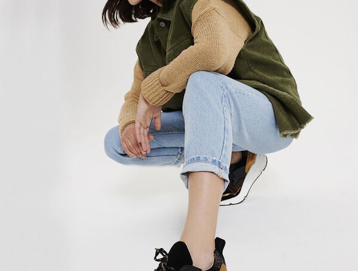 une femme avec des baskets a semelles epaises un jean et veste verte