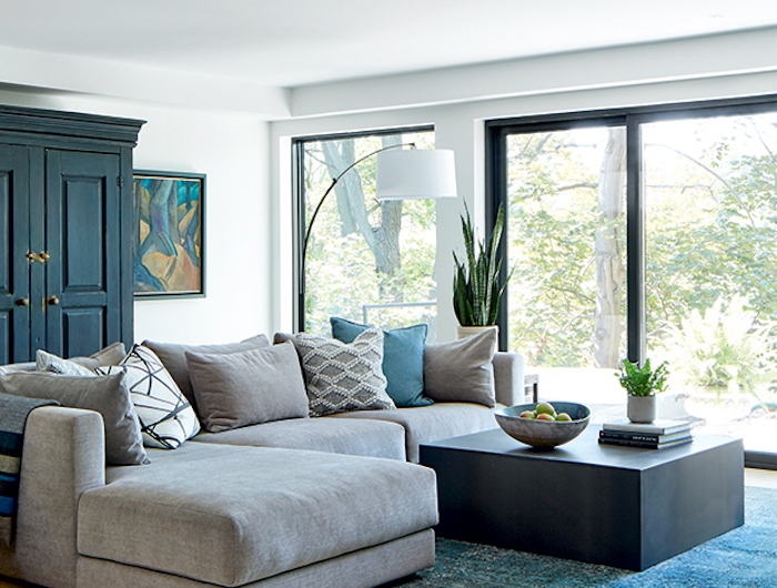 une salle de sejour avec des grandes fenetres un tapis turquois et canape en angle gris couleur tendance deco 2021
