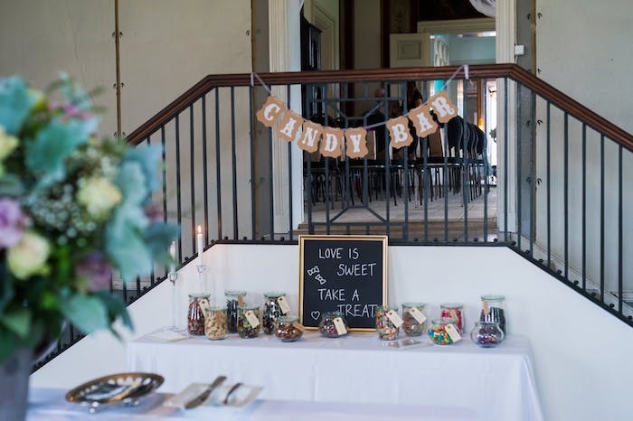 une table organisee comme un candy bar pres d un escalier avec des bonbonnieres