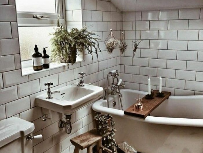 agencement salle de bain sous comble revêtue de carrelage metro blanc baignoire blanche parquet sale de bain plantes suspendues