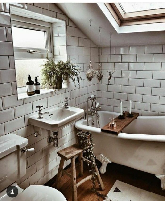 agencement salle de bain sous comble revêtue de carrelage metro blanc baignoire blanche parquet sale de bain plantes suspendues