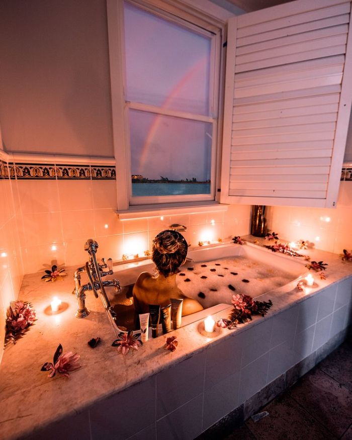 ambiance relaxante deco salle d ebain zen baignoire encastrée et décoré de bougies fleurs et pétales
