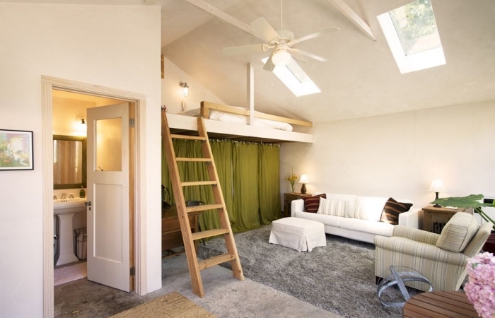 appartement mezzanine intérieur studio lit mezzanine ventilateur de plafond tapis moelleux gris canapé blanc