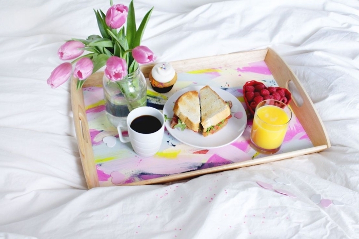 assiette ronde blanche petit déjeuner au lit verre jus orange fruits rouges bouquets tulipes