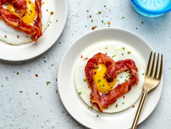 bacon rôti en forme de coeurs image petit déjeuner oeuf assiette blanche ronde repas romantique