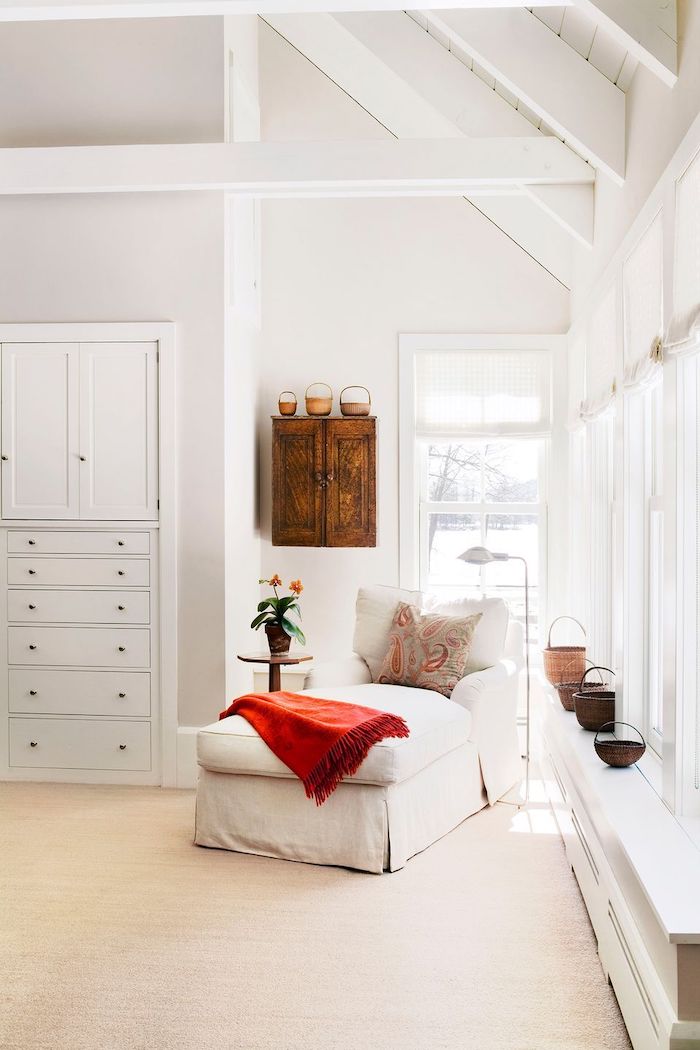 canapé tendance 2021 une chambre blanche avec des tissus naturels en cotton et un placerd au mur en style rustique