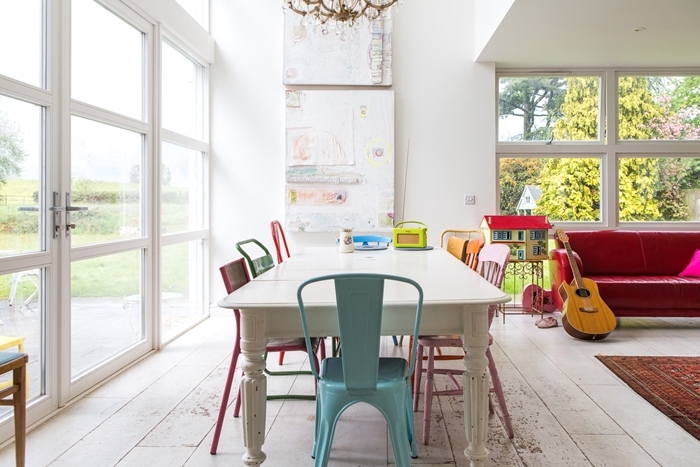 chaises colorées dans salle à manger table bois blanc design intérieur accents pops canapé rose fuschia