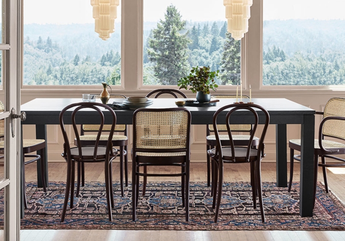 chaises dépareillées salle à manger table bois gris anthracite tapis foncé motifs ethniques fenêtres