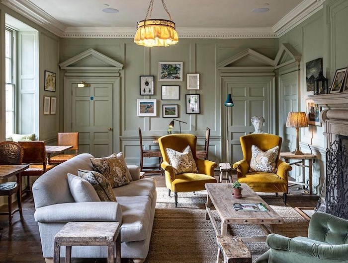couleur peinture salon tendance 2021 vert olive sur les murs et deux fauteuils en jaune avec une table rustique