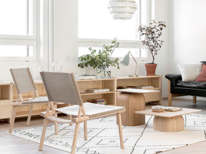 deco japandi interieur minimaliste avec chaises tables et meuble bas bois canapé cuir noir plantes suspension tapis blanc à la scandinave