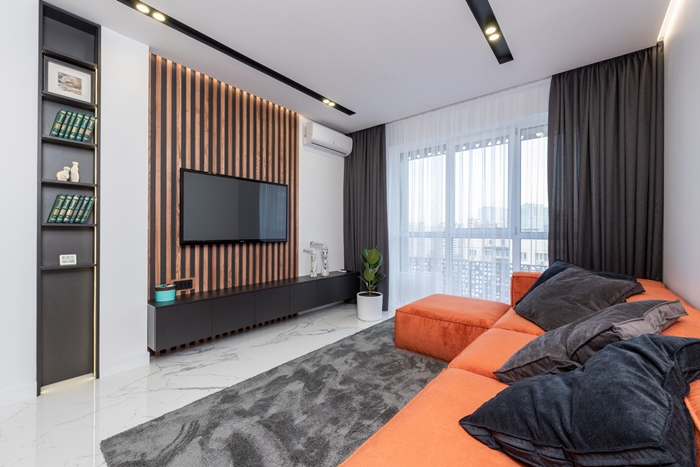 deco salon tapis gris canape d angle orange rideaux longs fonces mur blanc eclairage led meubles noirs