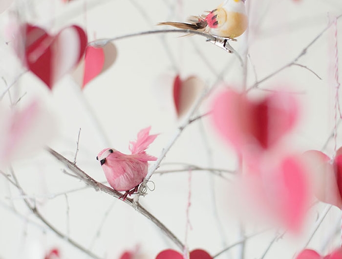 des petits oiseaux décoratifs penchée sur des branches dans une vase décoration saint valentin