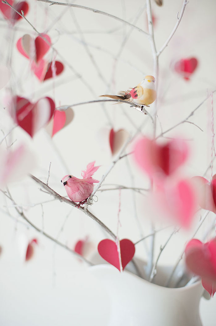 des petits oiseaux décoratifs penchée sur des branches dans une vase décoration saint valentin