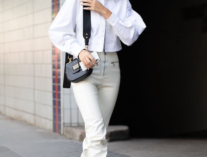 doc martens blanche une femme vetue en chemisier blanc avec un sac en cuir noir