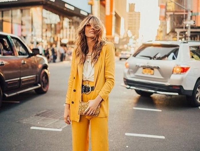 ensemble costume femme en jaune couleur pantone 2021 avec un ceinture au grand bouclier et des sandales blanc une femme dans un)grand boulevard