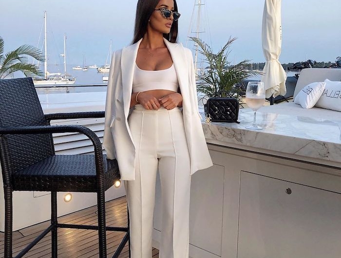 ensemble tailleur femme en blanc avec un top sourt une jeune femme au port maritime avec des lunette de soleil