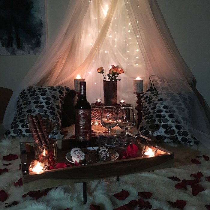 idée surprise saint valentin pour un diner au lit avec des petales de roses et des lumieres
