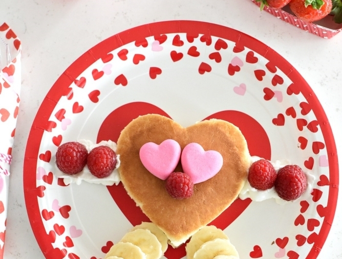 image petit déjeuner assiette ronde motifs coeurs rouges crêpe crème fraîche banane fraises