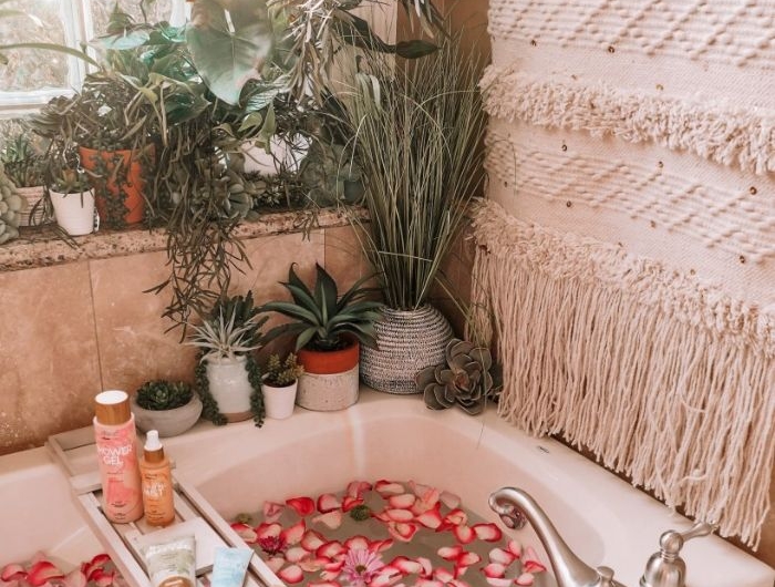 macramé murale dans salle de bain nature boheme chic avec baignoire blanche remplie de fleurs et pétales