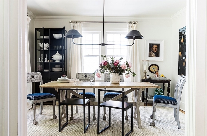 meuble salle à manger tapis blanc table bois chaises noires lustre meuble rangement ouvert noir portraits