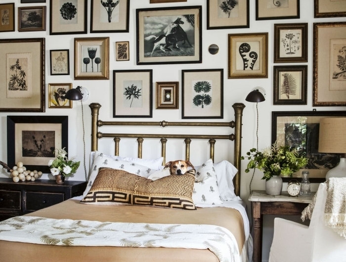 mur de cadres noirs et marron tete de lit fait maison peinture métallisée laiton meubles bois foncé ventilateur plafond