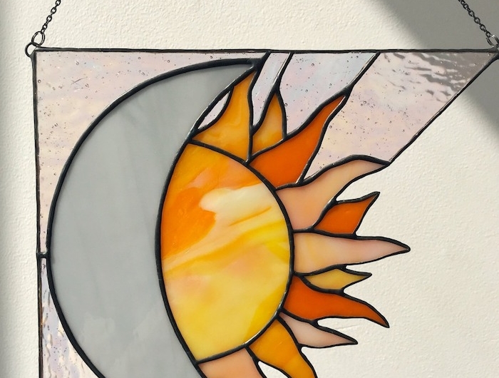 peinture sur verre avec une fogure de solei suspendu a un collier
