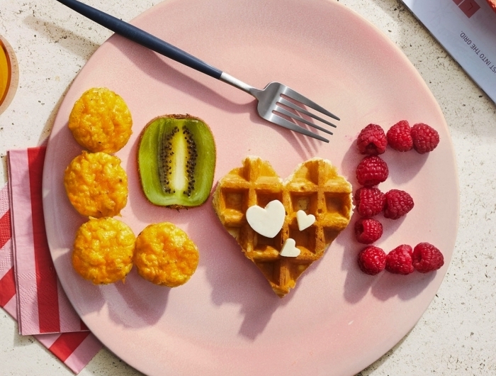 petit déjeuner équilibré assiette ronde rose pastel nourriture en forme de lettre amour fruits